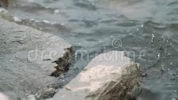 夏季的一天慢波撞击海岸岩层溅水快关门视频的预览图