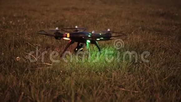 晚上带着摄像机的无人机试图从草地上起飞视频的预览图
