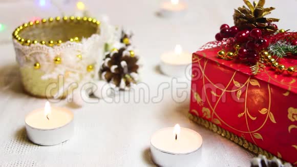 燃烧的蜡烛一个红色的礼品盒和装饰装饰的手电筒视频的预览图