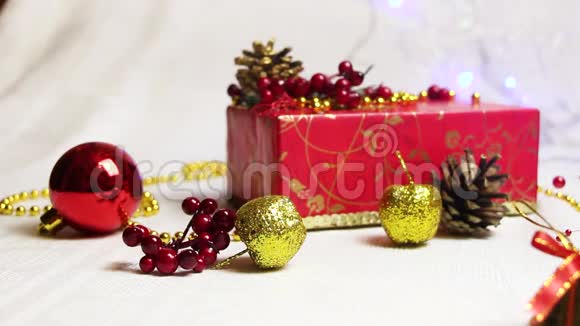 手工制作的红色礼品盒和圣诞装饰品金色的苹果和带有闪亮手电筒的凸起视频的预览图