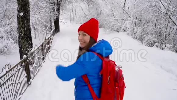 年轻女子用智能手机拍摄一幅美丽的冬季白雪覆盖的风景照片视频的预览图