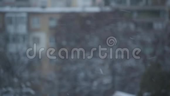 一座建筑物模糊的背景下降下的雪视频的预览图