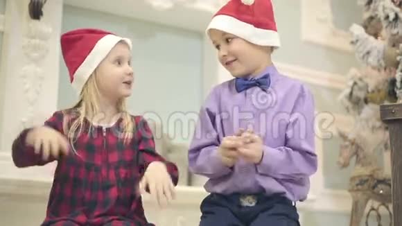 穿红裙子的小女孩和小男孩坐在地毯上拍手视频的预览图