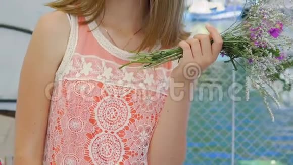 漂亮的女孩摆姿势手里拿着一束花在酒吧湾上慢慢地视频的预览图