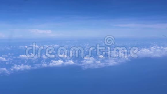 在地平线上明亮的蓝天上的蓬松的云彩蓝天白云从窗外的飞机上眺望视频的预览图