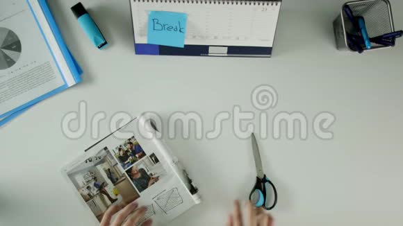 一个人坐在桌子旁贴纸上有字打破他从杂志上剪广告视频的预览图