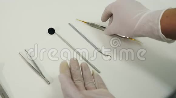 双手放在手套里从桌子上拿出牙科工具视频的预览图
