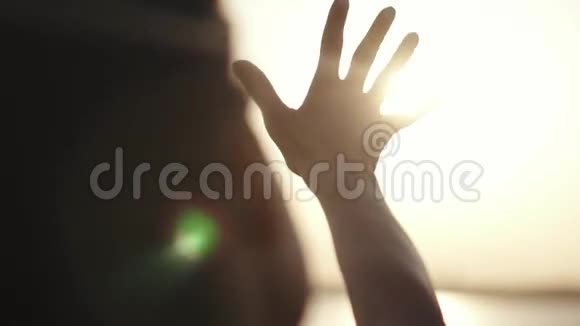 女孩用手看太阳女孩在日落时休息女人阳光下的手把手伸过来视频的预览图