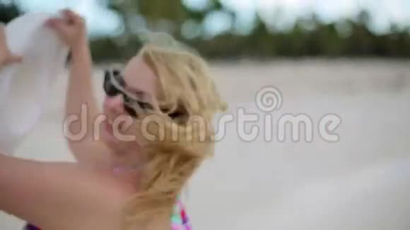 穿着比基尼在海滩上盘旋的年轻女子视频的预览图