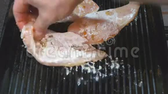 男人手把火鸡片放在一个热的煎锅烤架上准备自制排骨很好吃视频的预览图