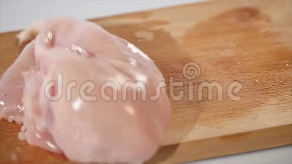 2块生鸡片落在木板上动作缓慢视频的预览图
