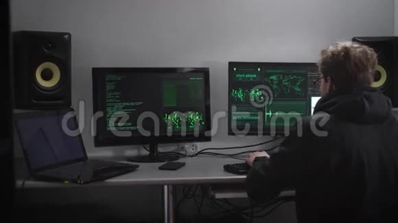关闭一个间谍与智能手表和手机坐在桌子与电脑显示器黑客试图获得视频的预览图
