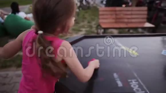 近距离观看快乐的小女孩打冰球夏季节日的体育比赛视频的预览图