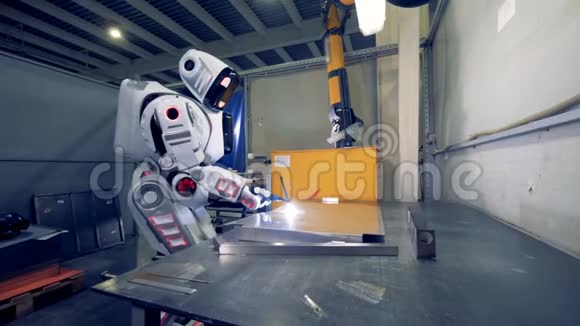 工厂机器人正在一家工厂使用焊接设备和一张金属片视频的预览图
