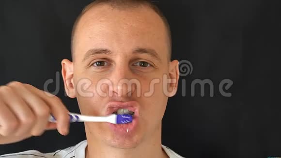 男人在黑色背景上刷牙视频的预览图