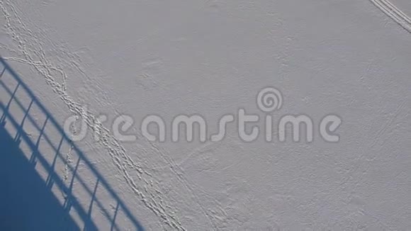 冬季湖面冰上蓝影木桥空中视频的预览图