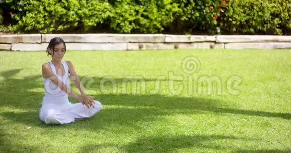 一个漂亮的单身女人在空荡荡的院子里伸胳膊视频的预览图