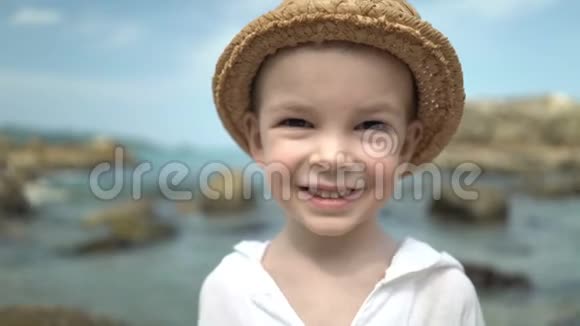 海滩上戴草帽的可爱男孩肖像视频的预览图