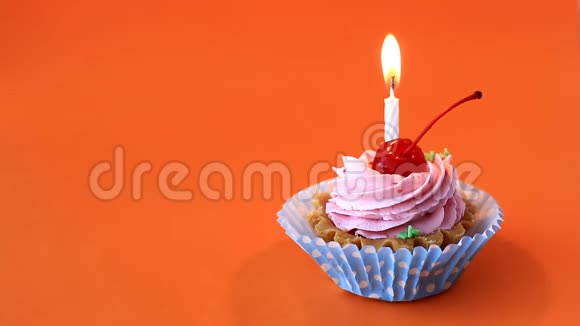 生日蛋糕上有樱桃粉色奶油和橙色背景的蜡烛视频的预览图