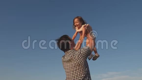 爸爸在蓝天上抛出一个快乐的女儿爸爸和小朋友一起玩一起笑一起拥抱幸福家庭视频的预览图