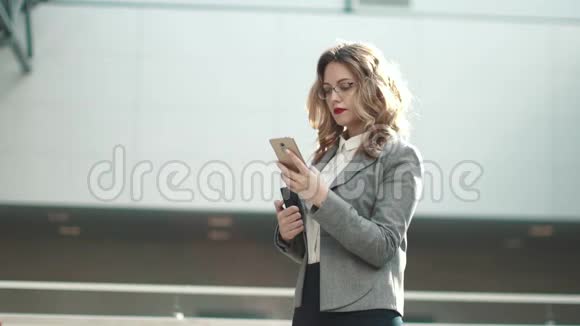 穿着西装的年轻女子在手机上打字办公大楼中一位女商人的肖像视频的预览图