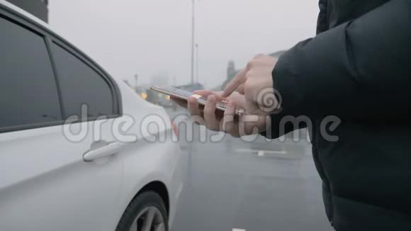 下雨天一个男人在车上用智能手机视频的预览图