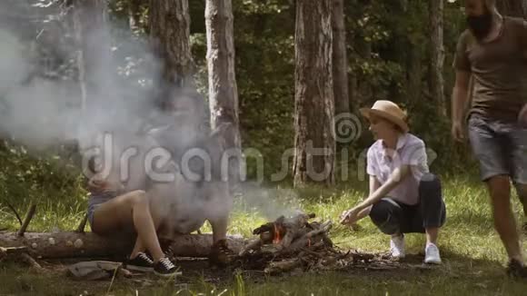 年轻人露营一群朋友露营他们坐在篝火旁视频的预览图