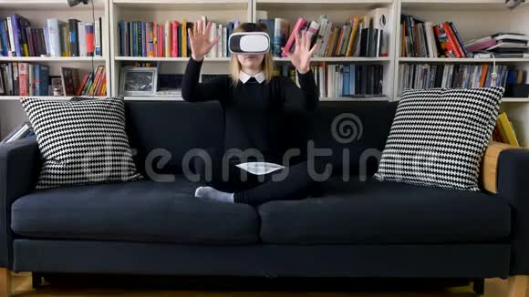 在沙发上戴虚拟现实护目镜的女孩视频的预览图