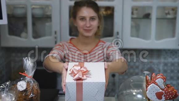 梳着马尾辫的女孩穿着一件浅色的t恤正抱着可爱的看着镜头白色的盒子在视频的预览图