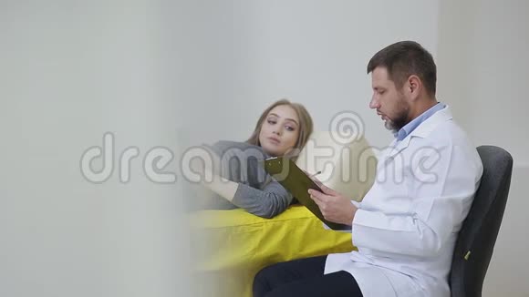 医生检查一名孕妇并在医疗预约卡上写信要求治疗视频的预览图