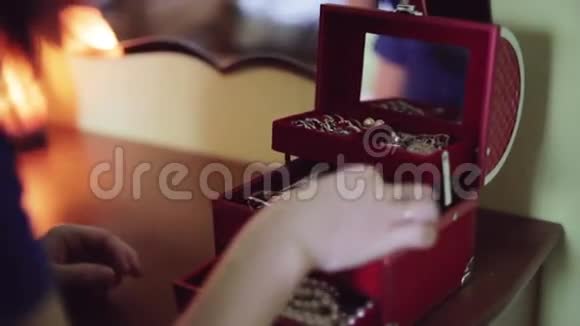 女人的手被从红色盒子里拿出来做珠宝手镯视频的预览图