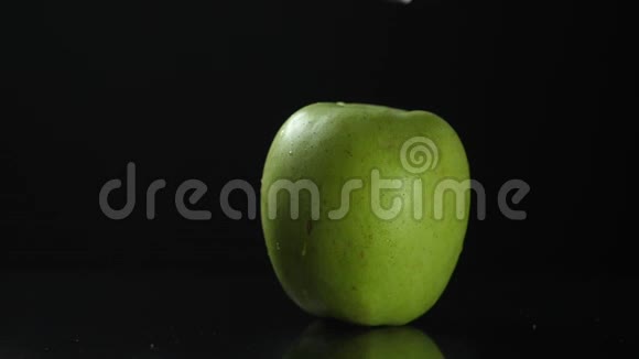 慢动作绿色苹果切片落在黑色背景高清视频的预览图
