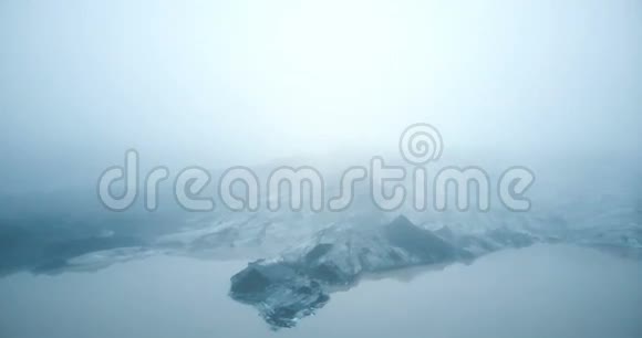 冰岛火山灰的默达尔斯乔卡尔冰川的鸟瞰图直升机在湖面冰山附近飞行在雾中视频的预览图