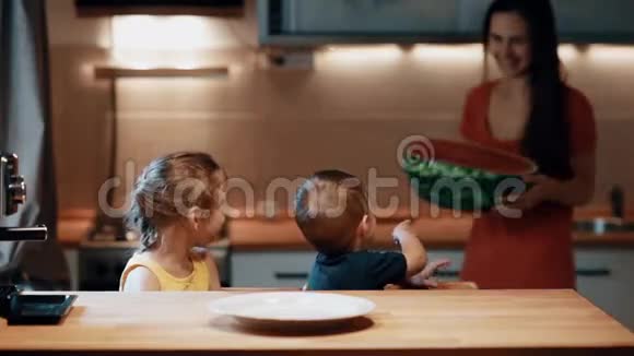 兄妹俩坐在桌旁幼妈妈端着半个西瓜放到桌上视频的预览图