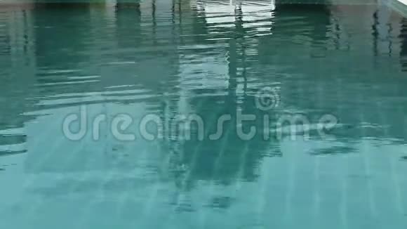 穿着黑色宽边和太阳镜的年轻女子在游泳池里休息视频的预览图