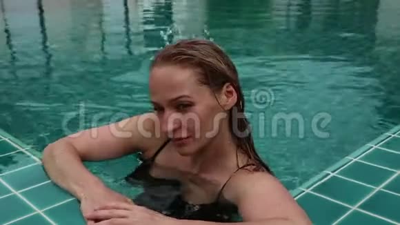 美丽快乐的苗条女人穿着黑色比基尼微笑着在酒店游泳池放松视频的预览图