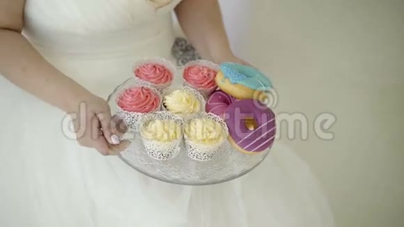穿婚纱的年轻女子拿着盘子和糖果视频的预览图