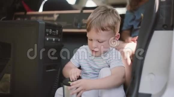 可爱的小男孩坐在车里一家人搬到新公寓在交通工具上搬运东西视频的预览图