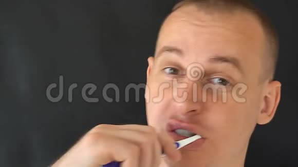 男人在黑色背景上刷牙视频的预览图