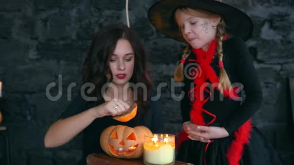 万圣节的小巫婆在黑色的背景下女孩拿着南瓜点燃蜡烛视频的预览图