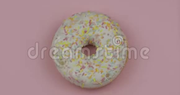 甜甜甜圈在粉红色背景上旋转上景美味新鲜的甜甜圈视频的预览图