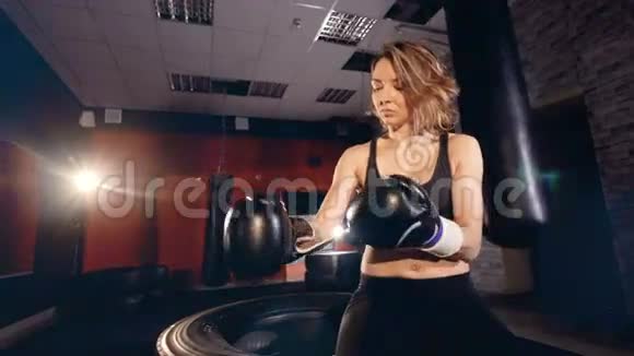 漂亮的女拳击手在健身室戴上拳击手套视频的预览图