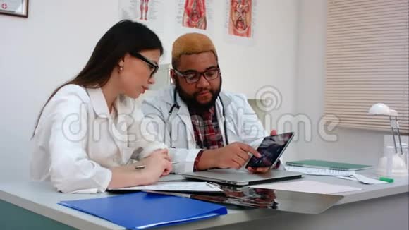 两位医生讨论平板电脑上的X光图像视频的预览图
