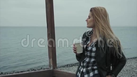 美丽的女人喝着咖啡看着大海视频的预览图