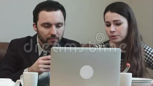 商务人士午餐时看着笔记本电脑屏幕边吃边喝视频的预览图