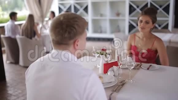 一对年轻夫妇在一家夏季餐厅交流视频的预览图