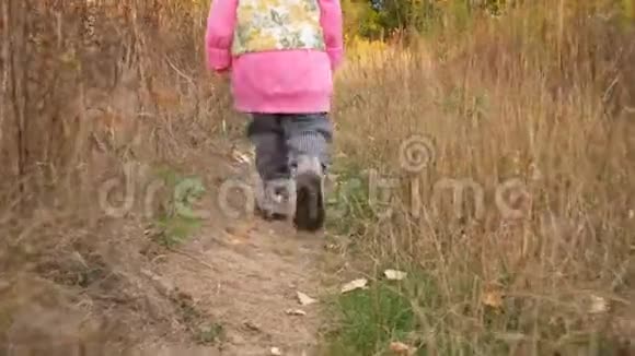一个孩子正沿着一条乡村道路走着穿着鞋子的婴儿脚秋天的风景视频的预览图
