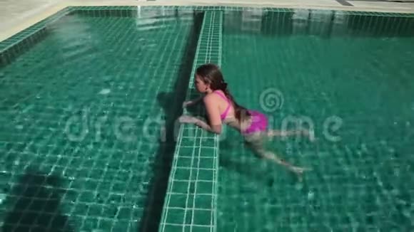 小女孩跳进游泳池里暑假的欢乐时光视频的预览图