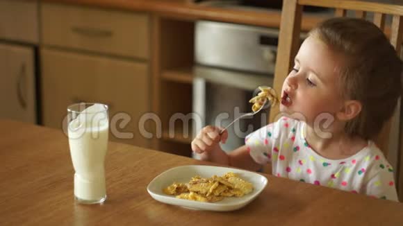 婴儿在厨房里吃鸡蛋他用叉子试一块把盘子推开热的食物视频的预览图