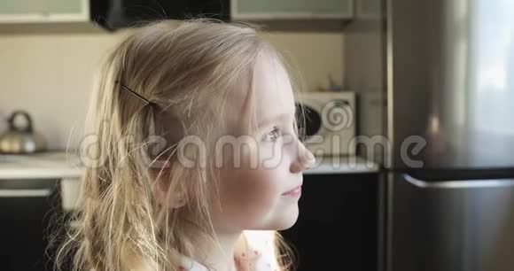 金发女孩正在厨房吃一个白色的蛋糕视频的预览图